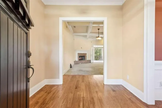 a view of an empty room with a window and chandelier fan