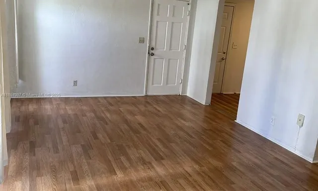 a kitchen with granite countertop white cabinets and refrigerator