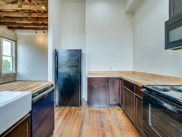 a kitchen with a refrigerator and a stove top oven