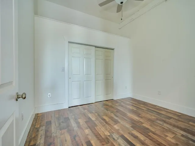 a view of empty room with wooden floor