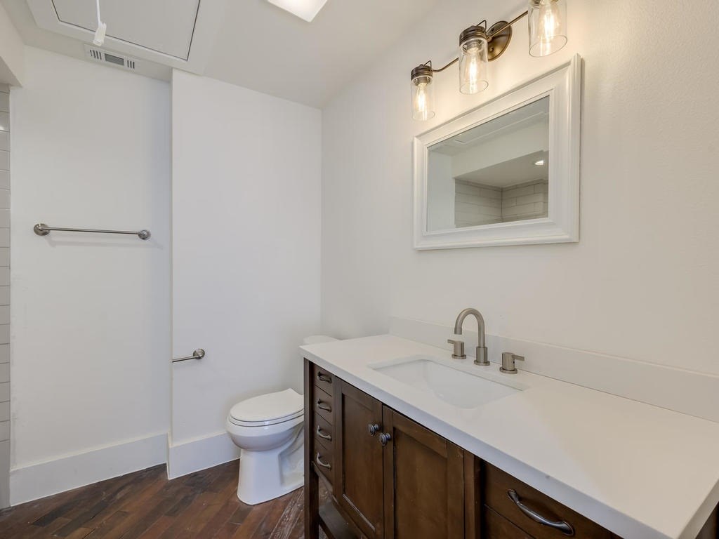 110 South Main Street, Unit 206 Elgin, TX 78621 - Photo 10 of 20 a bathroom with a toilet sink vanity and mirror