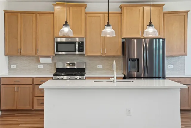 a kitchen with stainless steel appliances granite countertop a sink a stove and a wooden floors