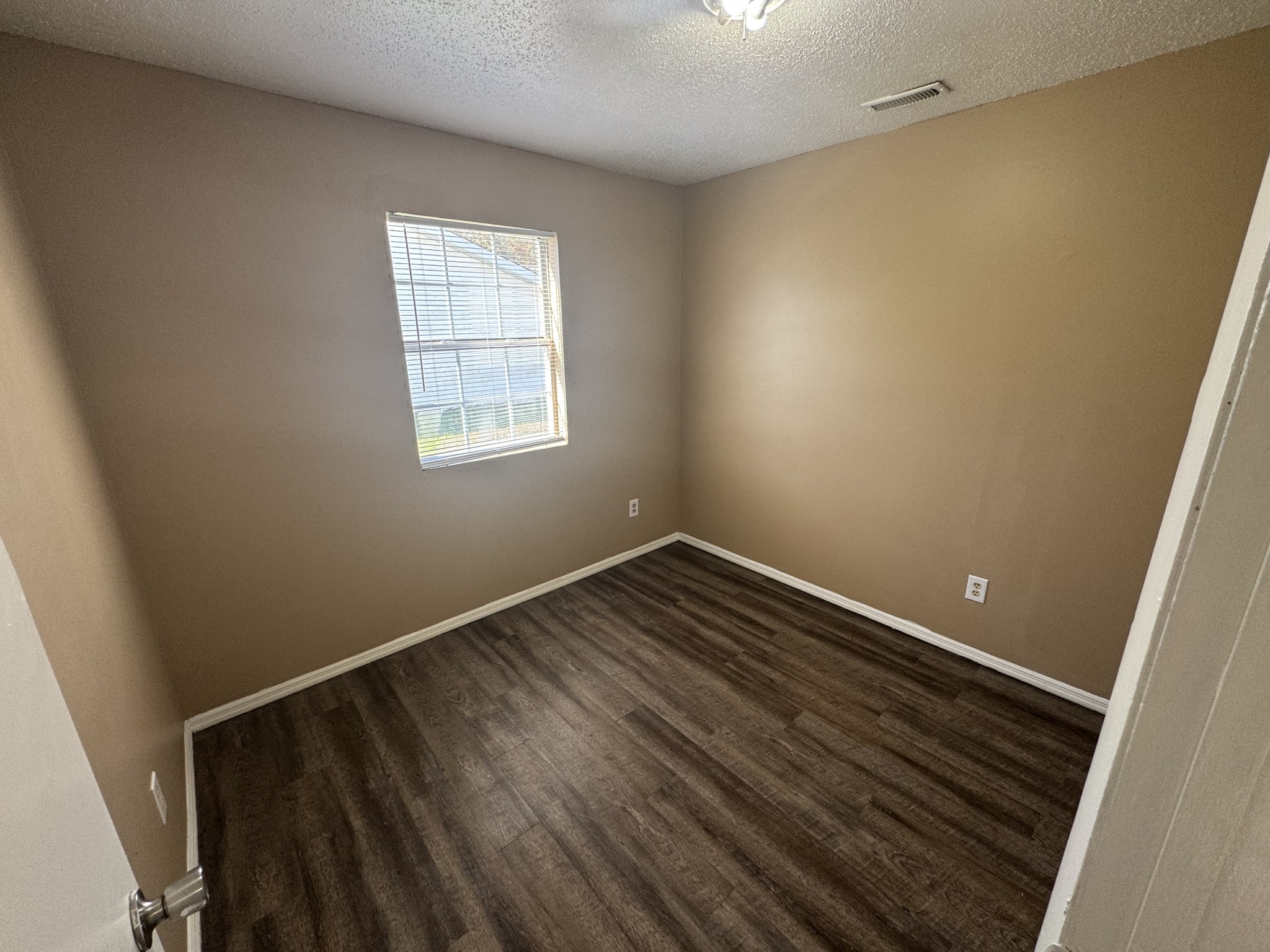 1523 Yager Road, Unit C3 McMinnville, TN 37110 - Photo 6 of 6 a view of an empty room with wooden floor and a window