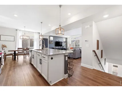 a open kitchen with wooden floor and stainless steel appliances