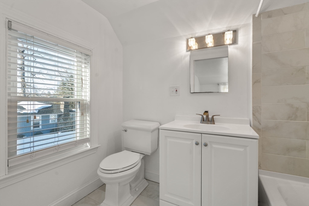 340 North Main Street Natick, MA 01760 - Photo 19 of 35 a bathroom with a toilet a sink a vanity and a window