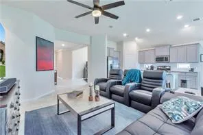 a living room with furniture and a view of kitchen