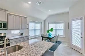 a kitchen with a sink a table and chairs in it