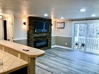 1619 Braley Road, Unit 98 New Bedford, MA 02745 - Photo 17 of 32 a living room with stainless steel appliances furniture a fireplace and a open kitchen view