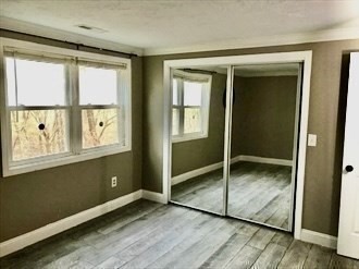 1619 Braley Road, Unit 98 New Bedford, MA 02745 - Photo 26 of 32 an empty room with wooden floor and windows