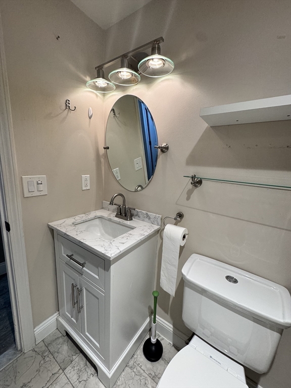 1619 Braley Road, Unit 98 New Bedford, MA 02745 - Photo 29 of 32 a bathroom with a granite countertop toilet sink and mirror