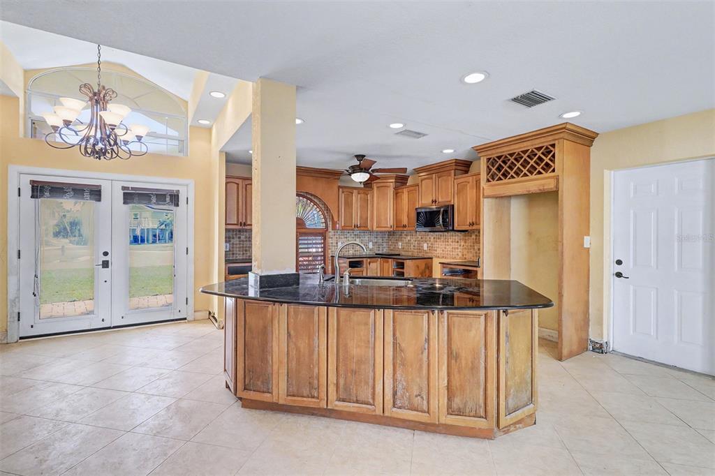 15918 Redington Drive Redington Beach, FL 33708 - Photo 7 of 33 a kitchen with stainless steel appliances kitchen island granite countertop a sink and cabinets