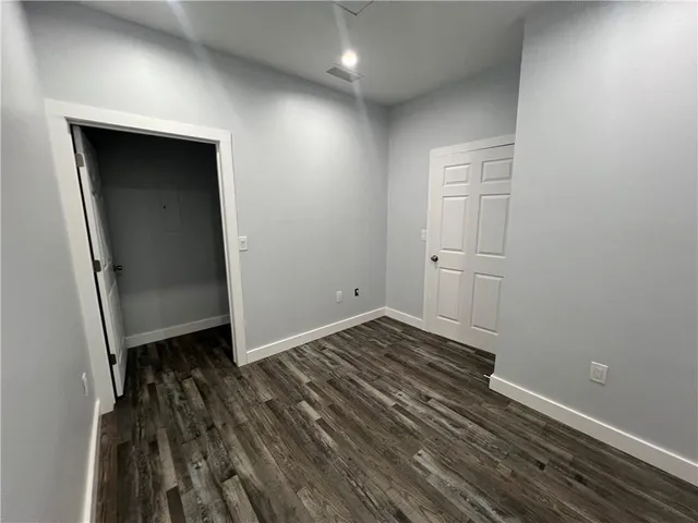 a view of a room with wooden floor and white walls