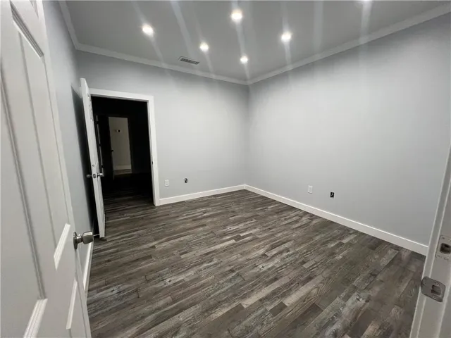 an empty room with wooden floor and entrance