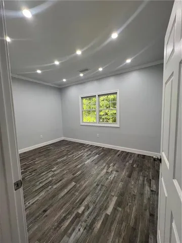an empty room with wooden floor and window