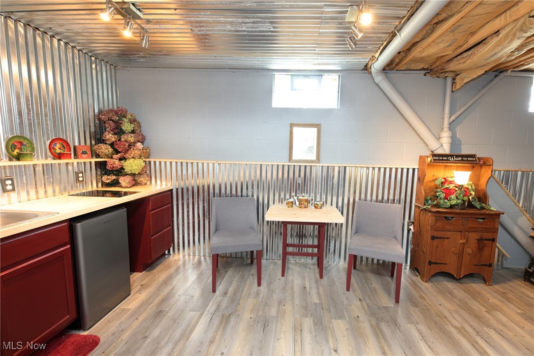 1313 Arner Road Chester, WV 26034 - Photo 35 of 46 Bar area featuring light countertops, light wood-style flooring, stainless steel fridge, and reddish brown cabinets
