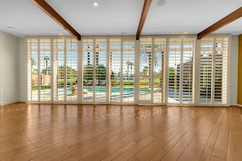a view of a livingroom with an empty space & a ceiling fan