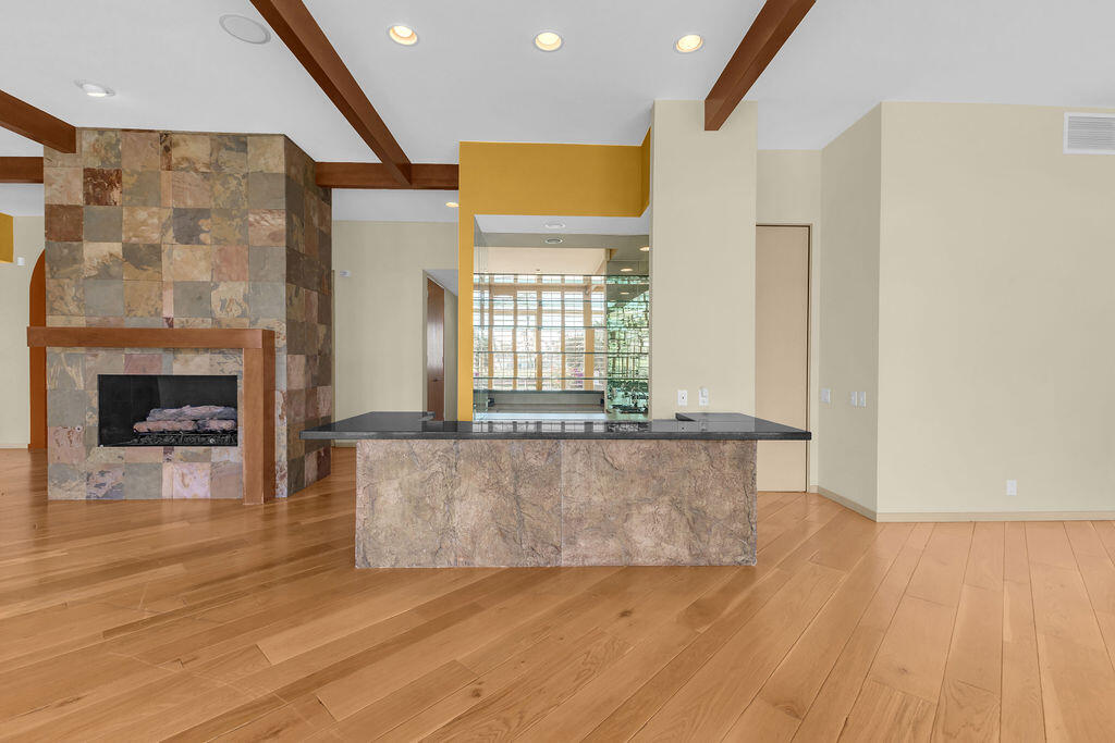 1421 Tamarisk W Street, Unit 3 Rancho Mirage, CA 92270 - Photo 13 of 65 a living room with granite countertop wooden floor and a fireplace