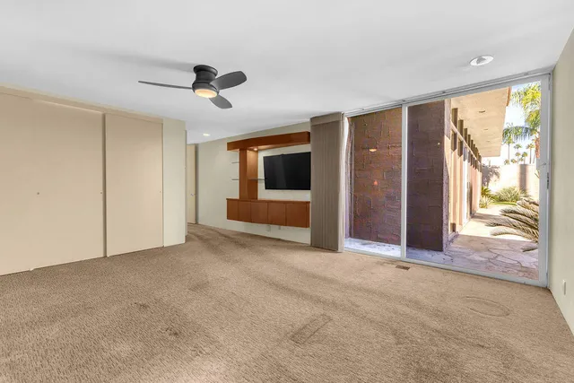 a view of a hallway and a livingroom with furniture