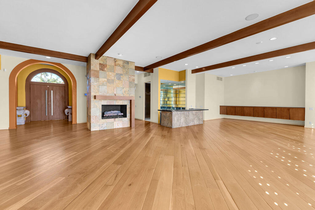 1421 Tamarisk W Street, Unit 3 Rancho Mirage, CA 92270 - Photo 8 of 65 a view of an empty room with wooden floor and a fireplace