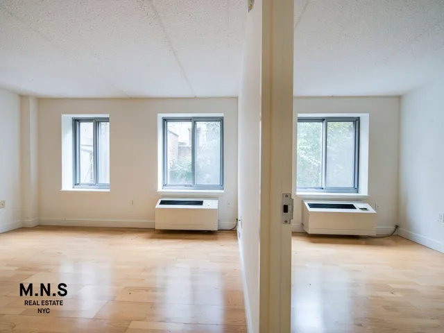 a view of a bedroom with furniture and windows