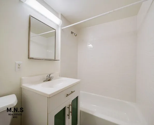 a bathroom with a sink mirror vanity and toilet