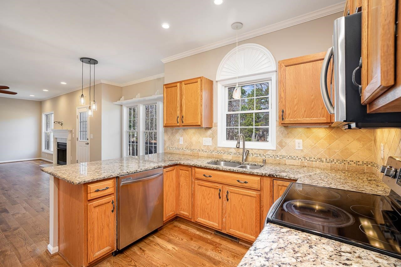 8409 Neuse Timbers Court Raleigh, NC 27616 - Photo 9 of 30 Kitchen boasts stainless appliances, custom lighting and overlooks not only your expansive family room but your oversized deck and the pond in your private back yard setting Kitchen