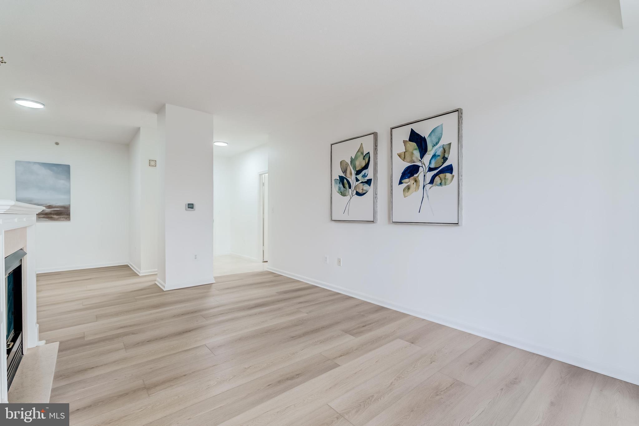 19355 Cypress Ridge Terrace, Unit 114 Leesburg, VA 20176 - Photo 17 of 42 a view of an empty room with wooden floor and a painting