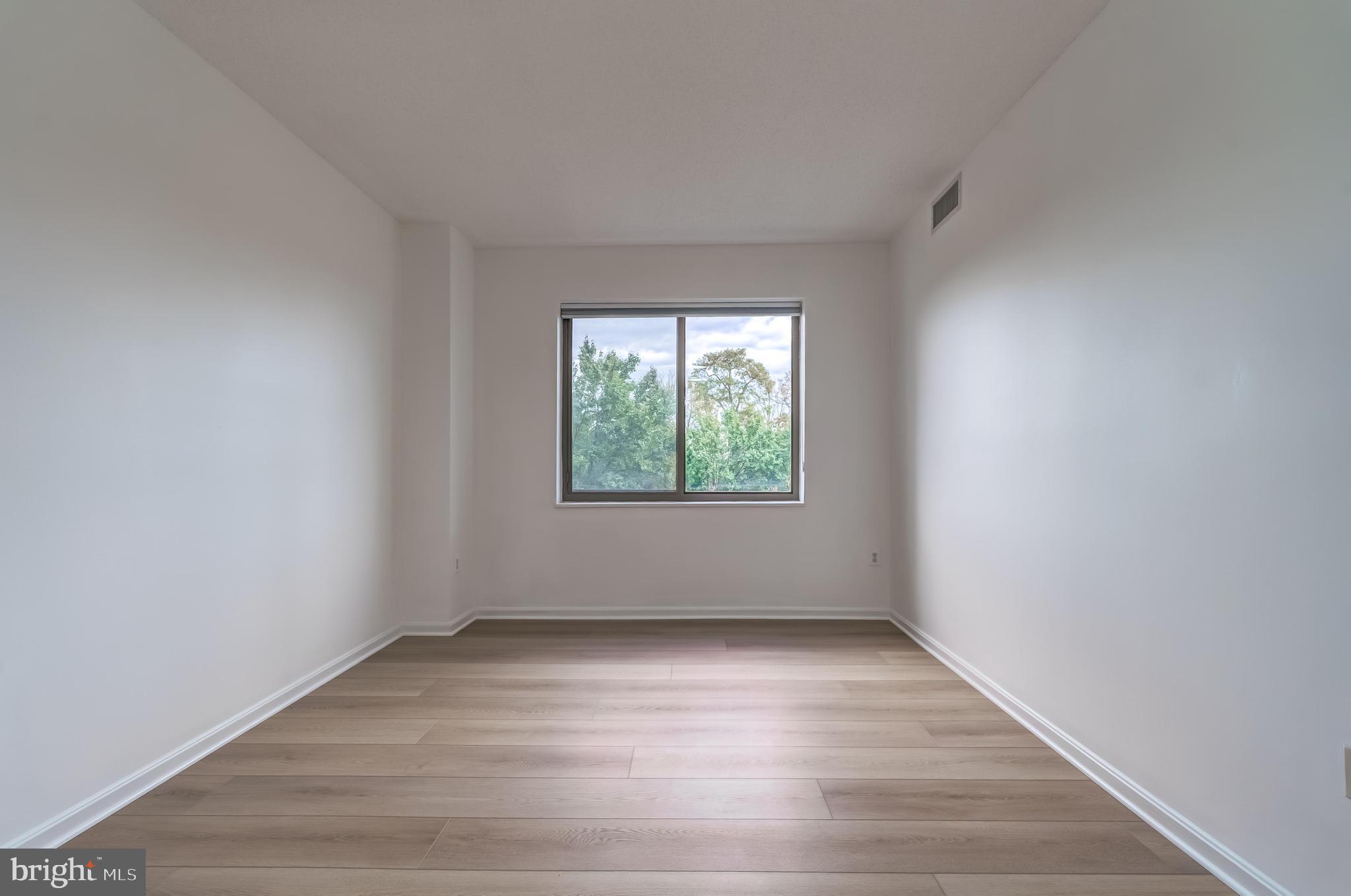 19355 Cypress Ridge Terrace, Unit 114 Leesburg, VA 20176 - Photo 20 of 42 an empty room with wooden floor and windows