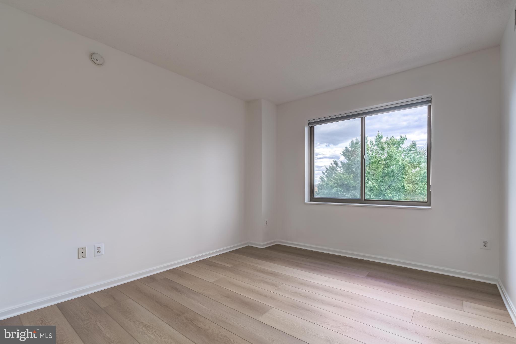 19355 Cypress Ridge Terrace, Unit 114 Leesburg, VA 20176 - Photo 21 of 42 an empty room with wooden floor and windows