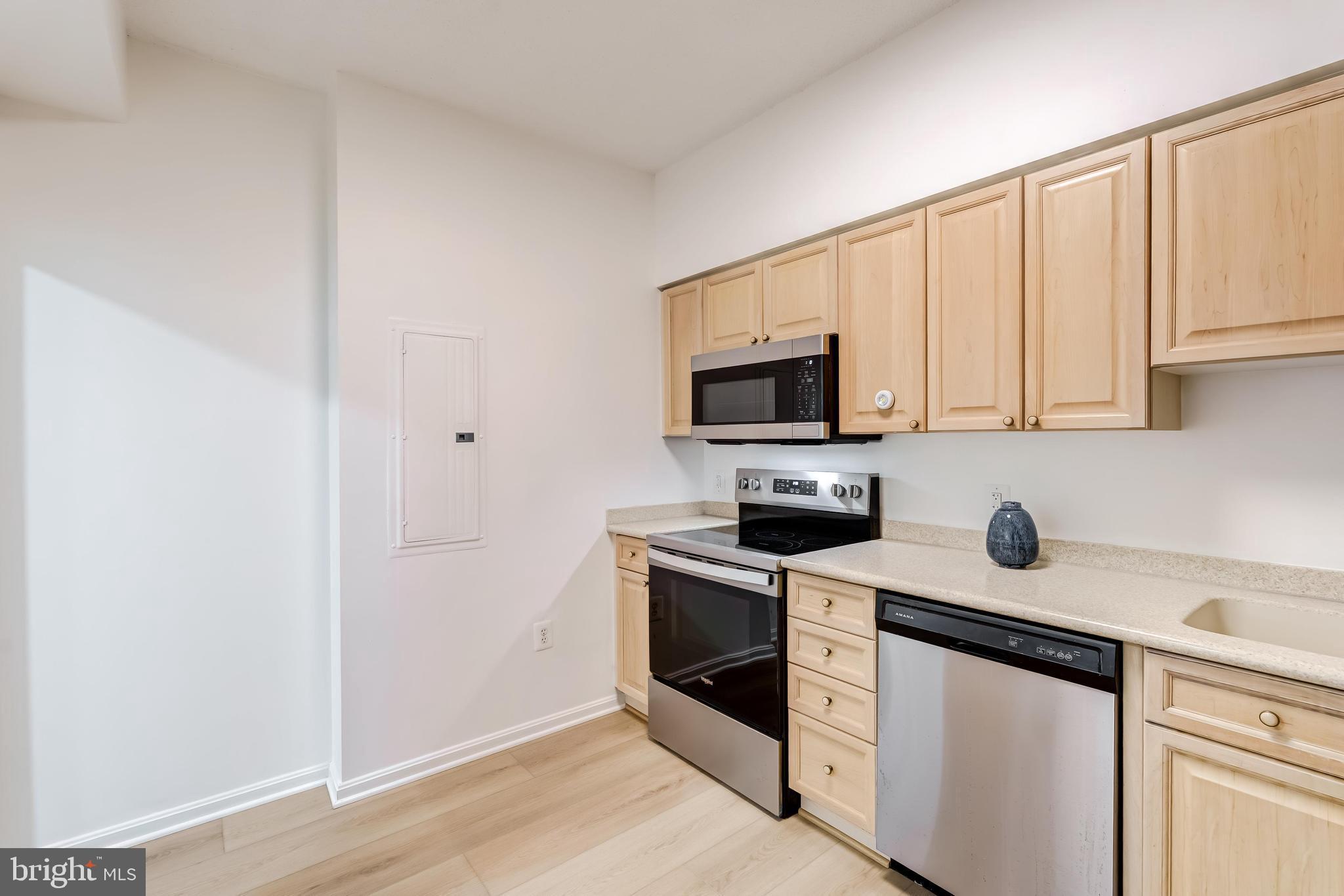 19355 Cypress Ridge Terrace, Unit 114 Leesburg, VA 20176 - Photo 7 of 42 a kitchen with white cabinets stainless steel appliances and sink