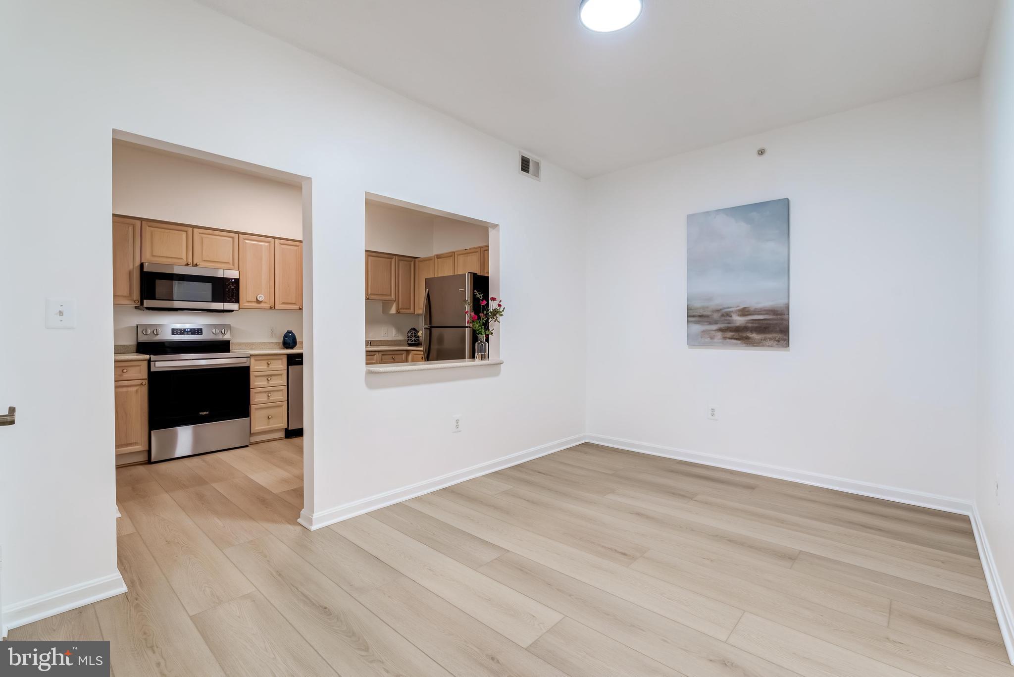 19355 Cypress Ridge Terrace, Unit 114 Leesburg, VA 20176 - Photo 8 of 42 a view of a kitchen with wooden floor and electronic appliances