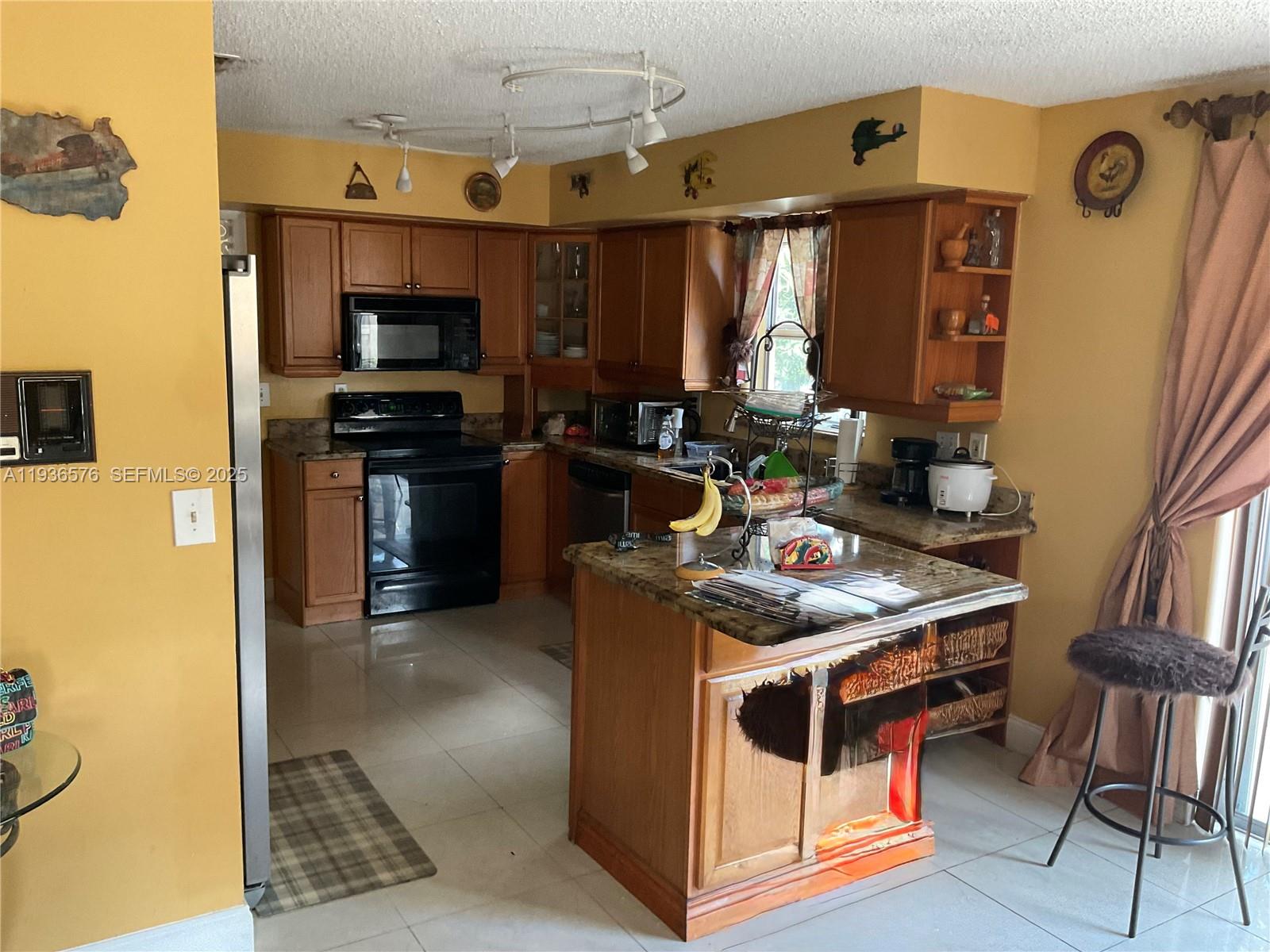 3161 Venice Way Miramar, FL 33025 - Photo 11 of 37 a kitchen with stainless steel appliances granite countertop a stove and a refrigerator