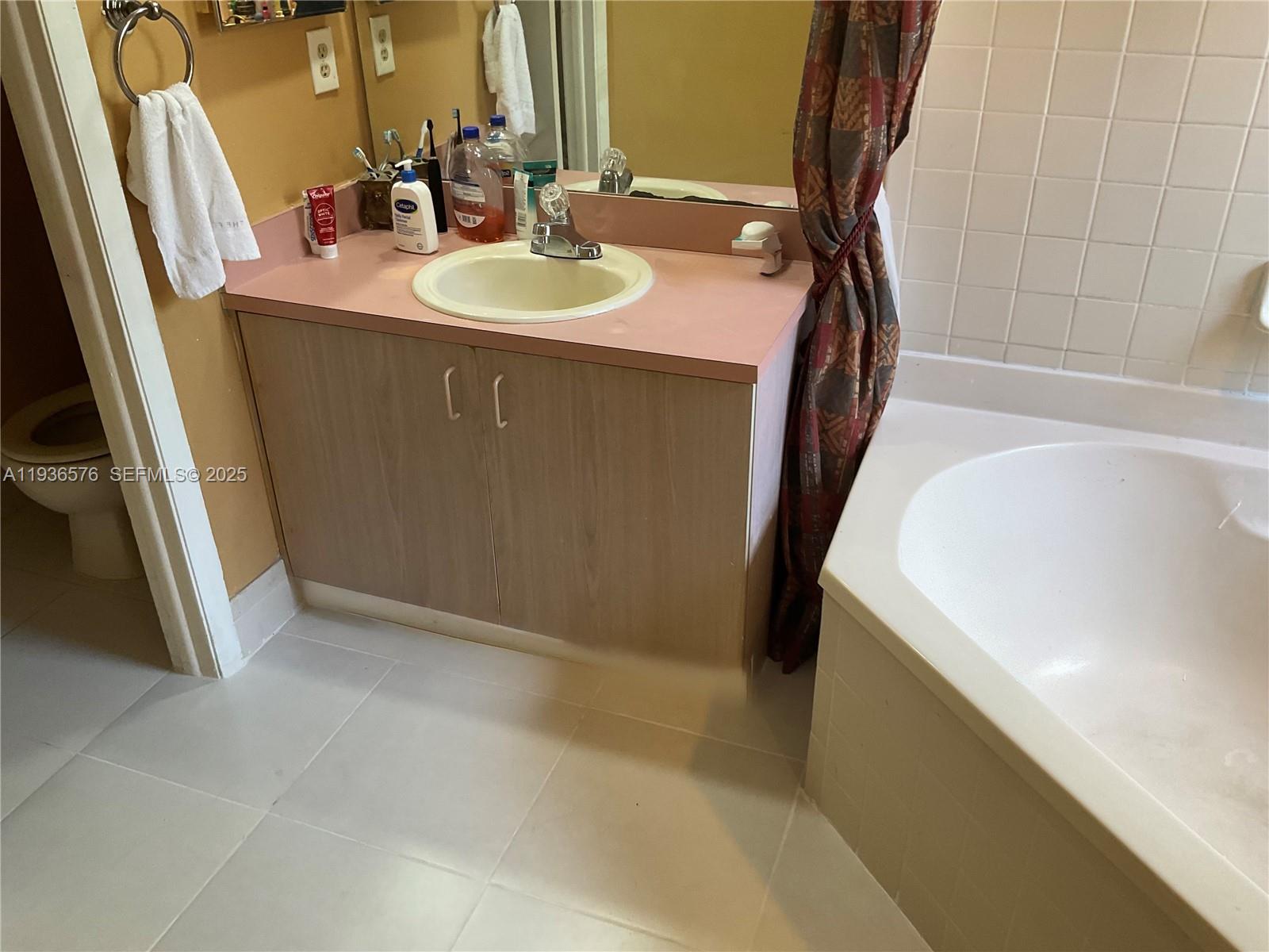 3161 Venice Way Miramar, FL 33025 - Photo 27 of 37 a bathroom with a sink a tub and a mirror
