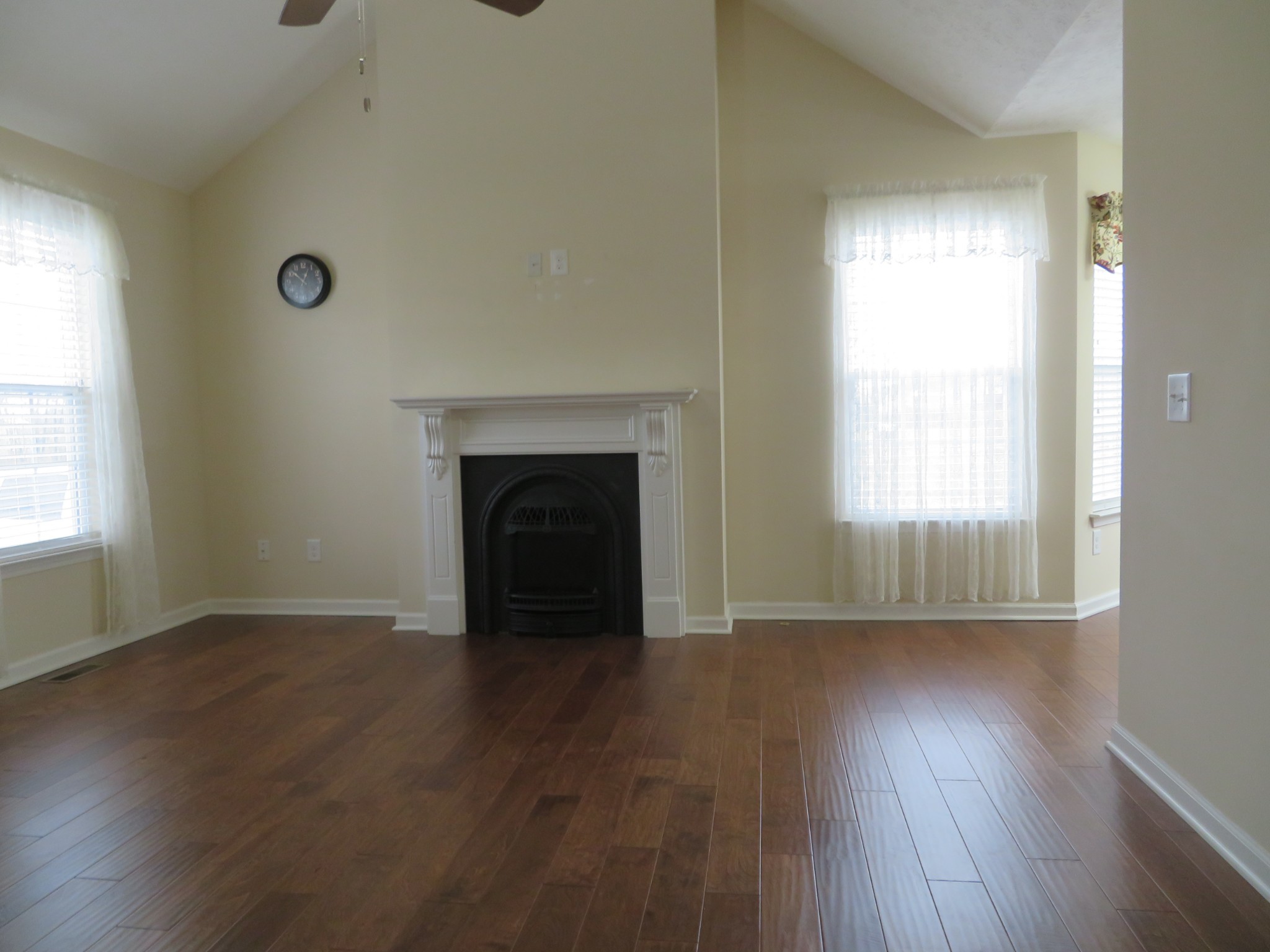 210 Shaub Road Portland, TN 37148 - Photo 5 of 22 an empty room with wooden floor a fireplace and windows