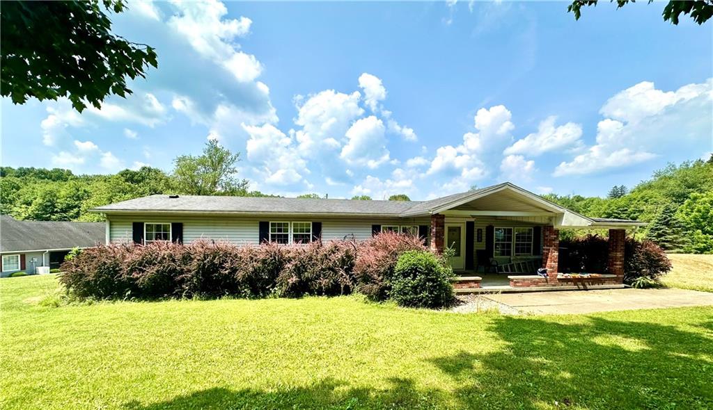 a front view of a house with yard and green space