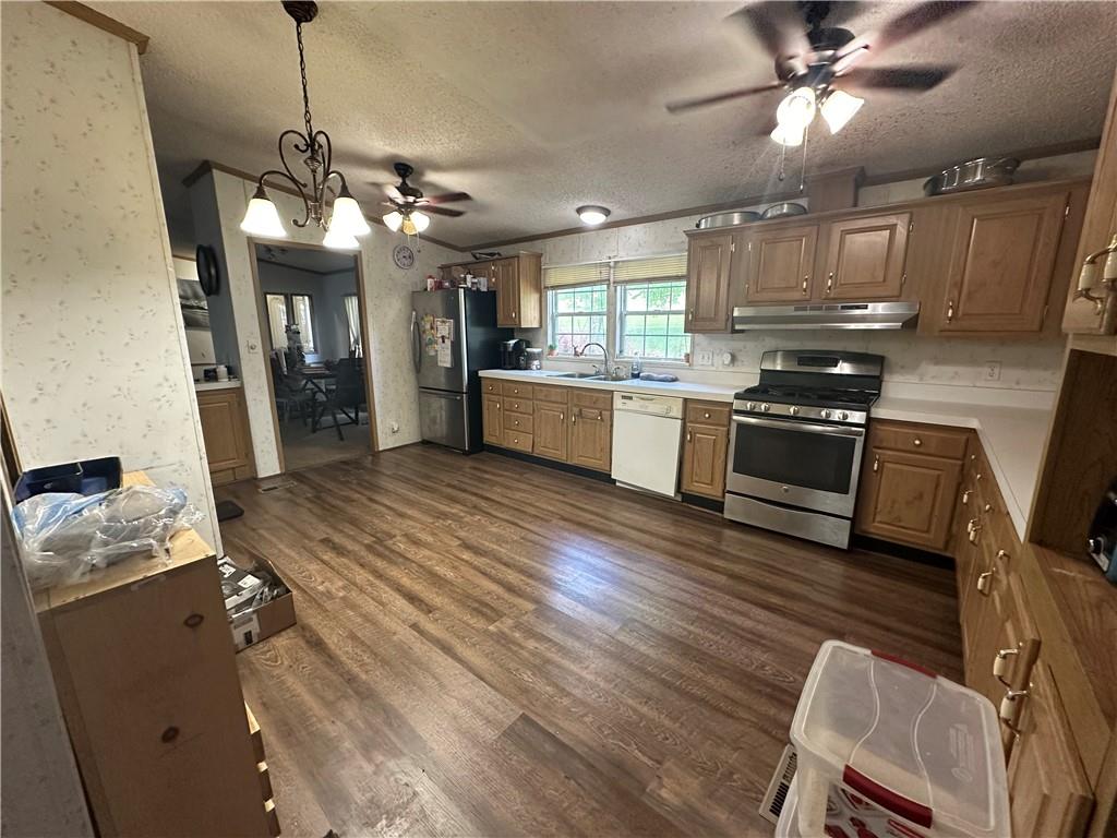 107 Rose Lane Rimersburg, PA 16248 - Photo 11 of 25 a kitchen with stainless steel appliances granite countertop a refrigerator a sink dishwasher a stove and white countertops with wooden floor