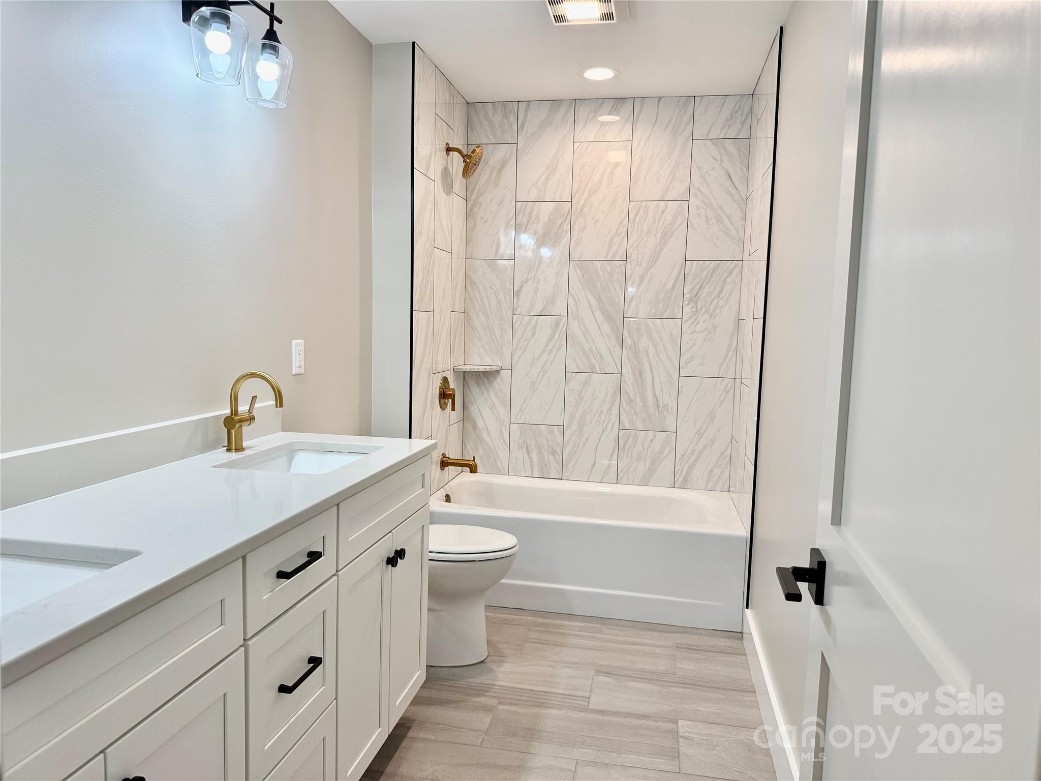 296 Gallimore Road Brevard, NC 28712 - Photo 30 of 36 a bathroom with a granite countertop sink a toilet and a bathtub