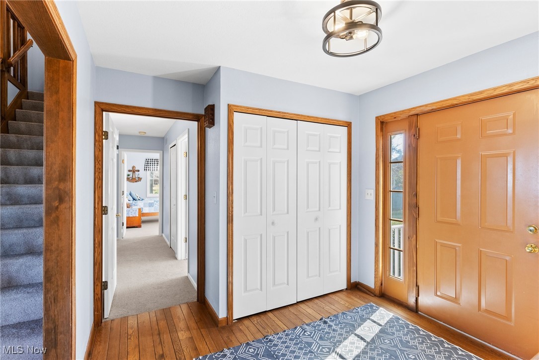 1122 Lake Road Conneaut, OH 44030 - Photo 21 of 50 Entryway featuring baseboards, a healthy amount of sunlight, stairway, and wood-type flooring