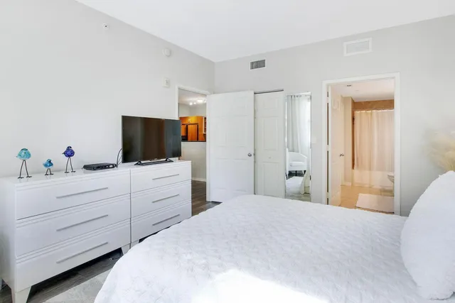 a bedroom with a flat screen tv and a dresser