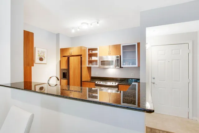 a kitchen with stainless steel appliances granite countertop a refrigerator and a stove
