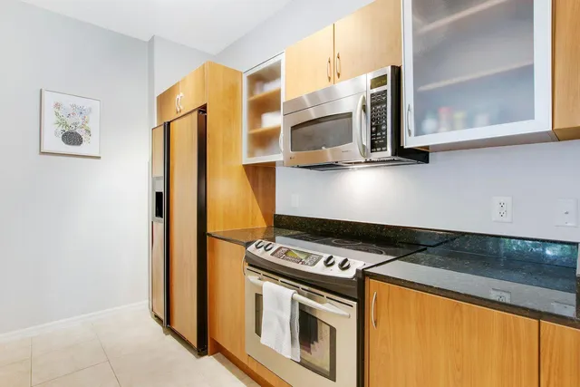 a kitchen with stainless steel appliances granite countertop a stove and a microwave
