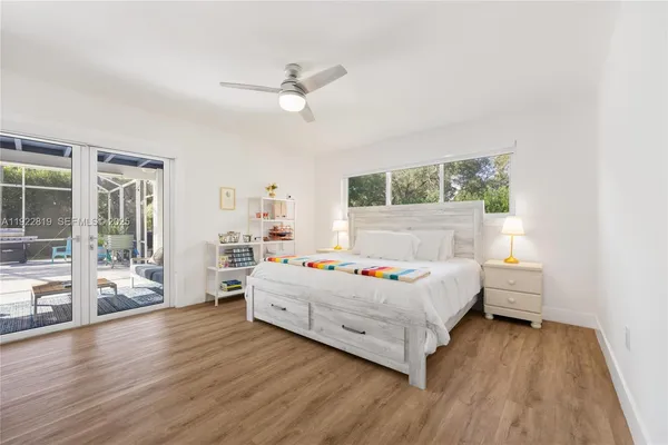 a white bed sitting in a room next to a window