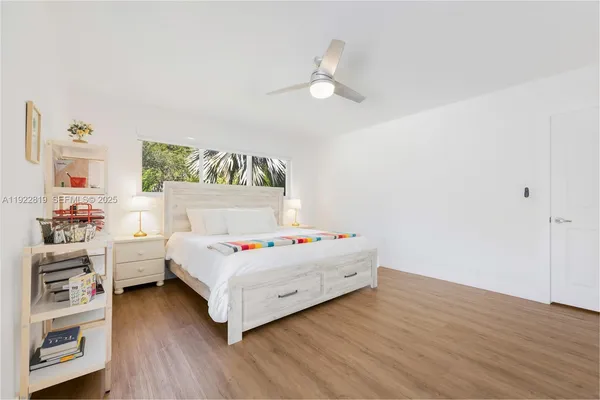 a white bed sitting in a bedroom next to a window