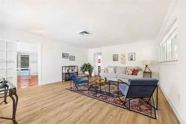 a living room with furniture and wooden floor