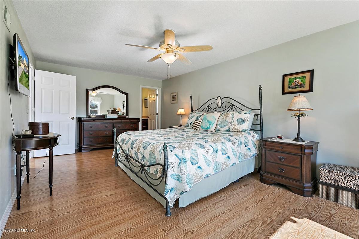 1870 Seminole Road Atlantic Beach, FL 32233 - Photo 12 of 27 a bedroom with a large bed and a chandelier