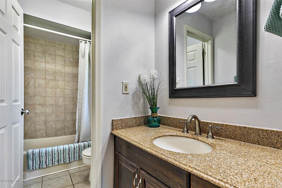 1870 Seminole Road Atlantic Beach, FL 32233 - Photo 16 of 27 a bathroom with a granite countertop sink a toilet and a mirror