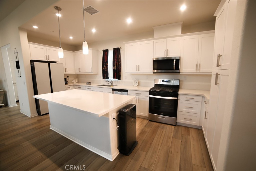 367 South Gardena Avenue Rialto, CA 92376 - Photo 1 of 1 a kitchen with a sink a microwave a refrigerator and cabinets