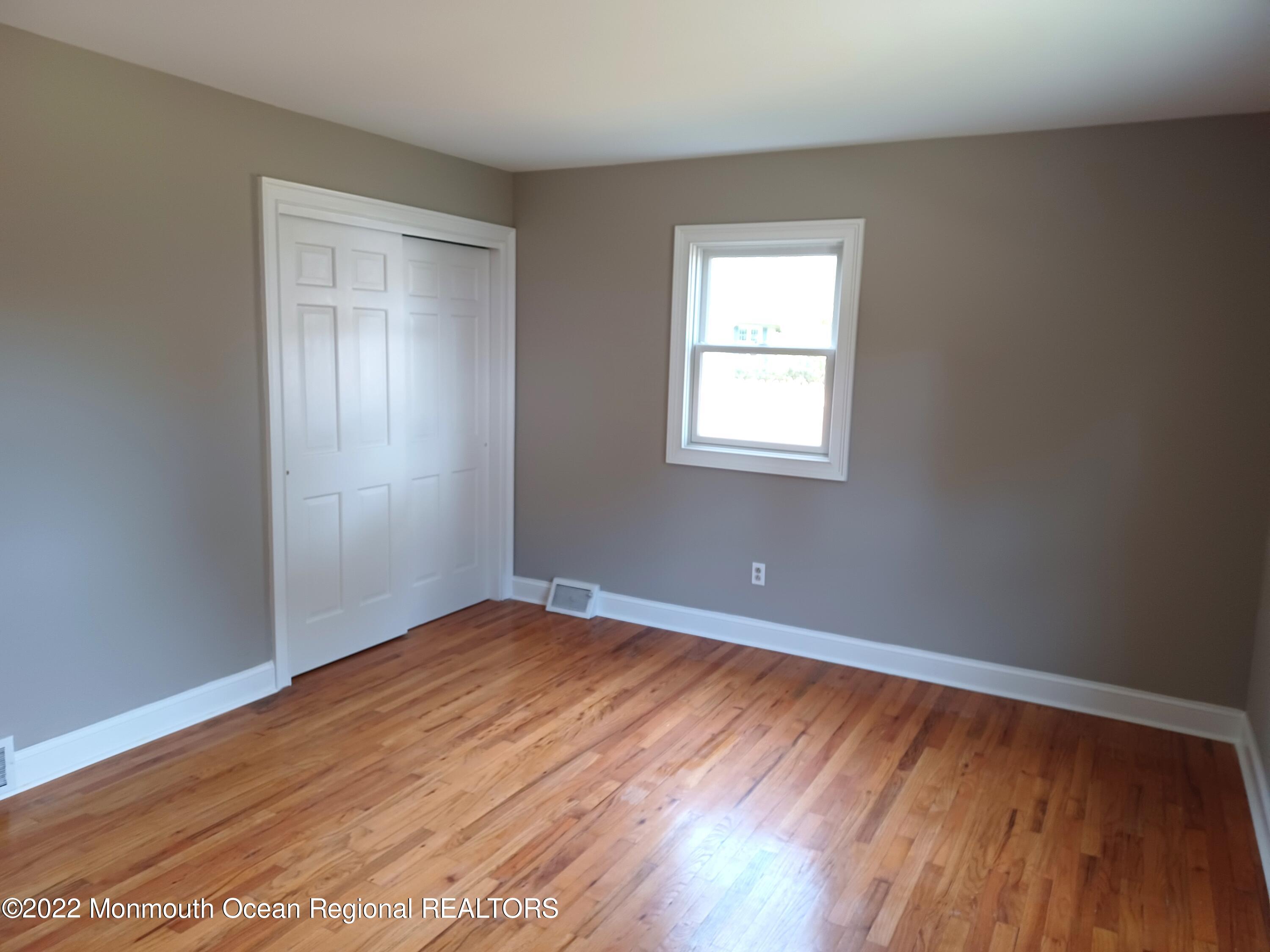 1301 Charles Street Point Pleasant, NJ 08742 - Photo 15 of 24 an empty room with wooden floor and windows