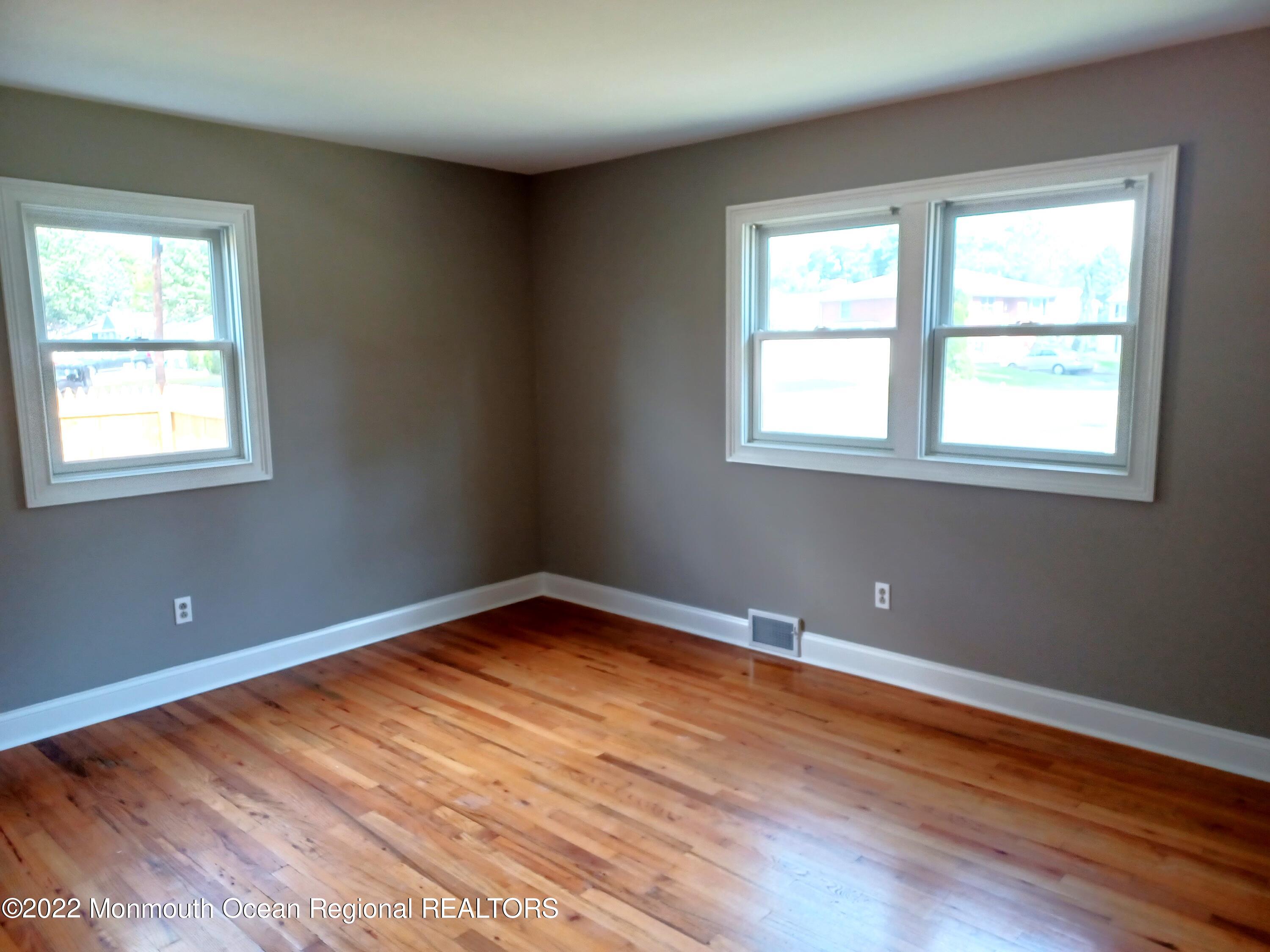1301 Charles Street Point Pleasant, NJ 08742 - Photo 16 of 24 an empty room with wooden floor and windows