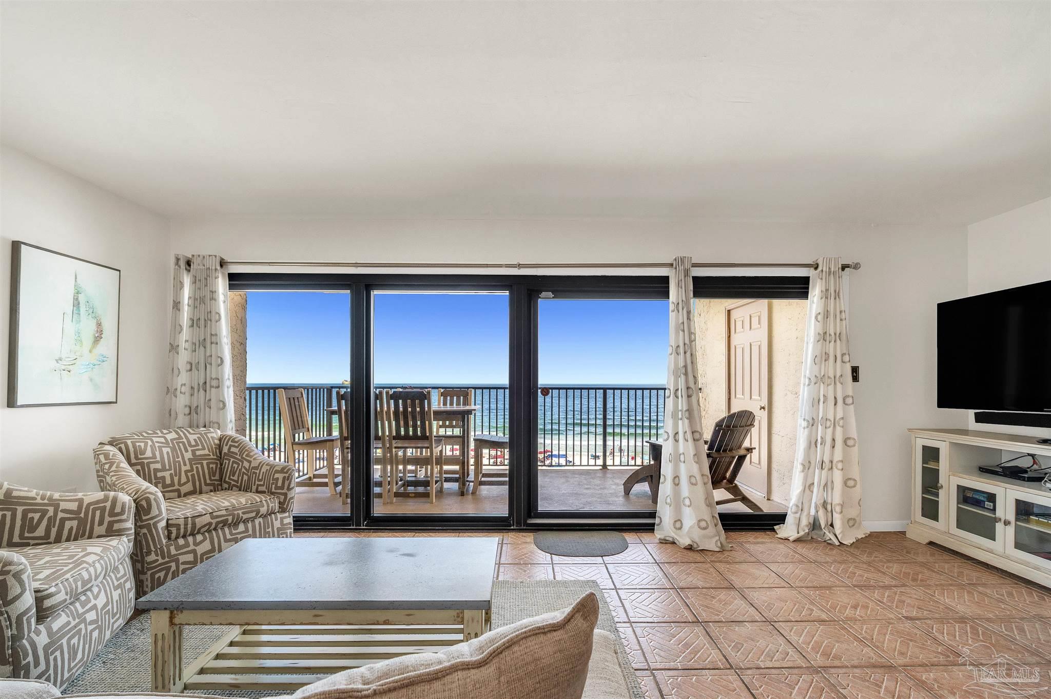 13817 Perdido Key Drive, Unit 501 Pensacola, FL 32507 - Photo 20 of 63 a living room with furniture a flat screen tv and a floor to ceiling window